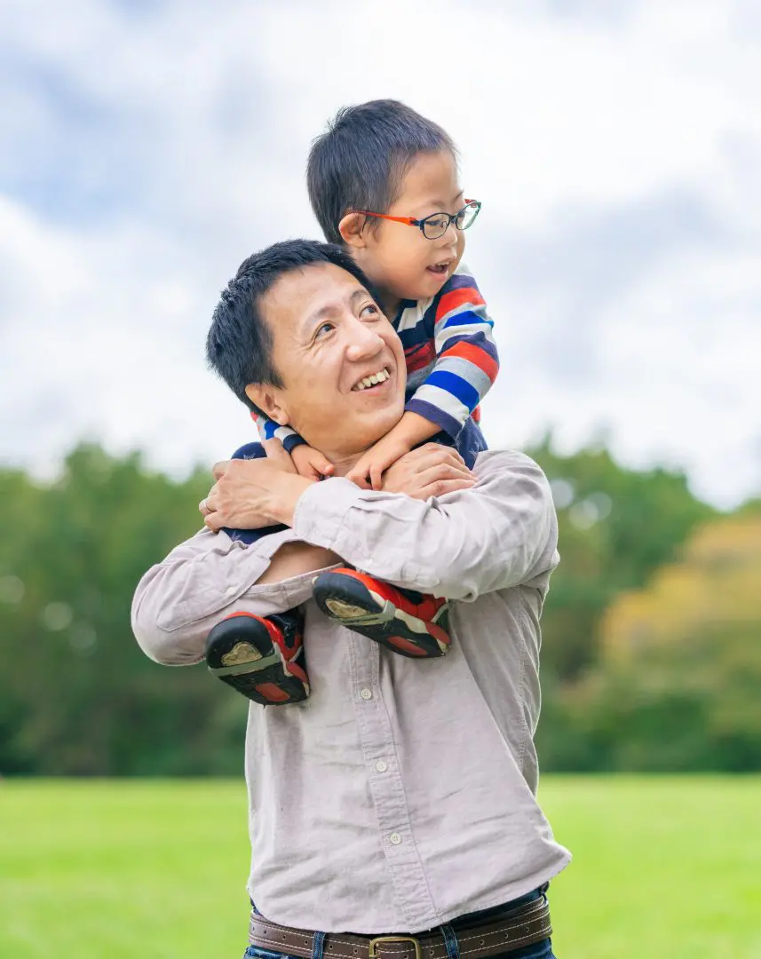 Image: picture of a father and his son on his shoulders. Both with light skin and dark hair
