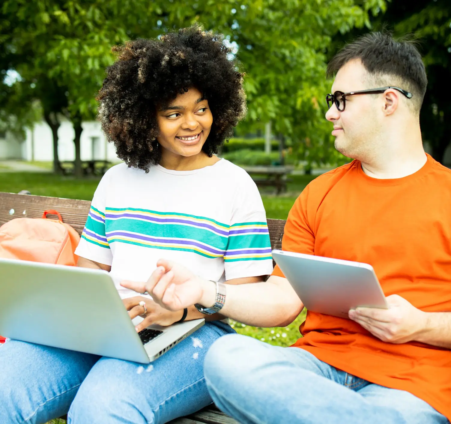Two people with laptops smiling